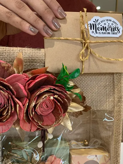A welcome hamper for a groom-to-be from his new family. The jute bag is decorated with sola wood flowers and a sticker that says, 'The best thing about memories is making them'.