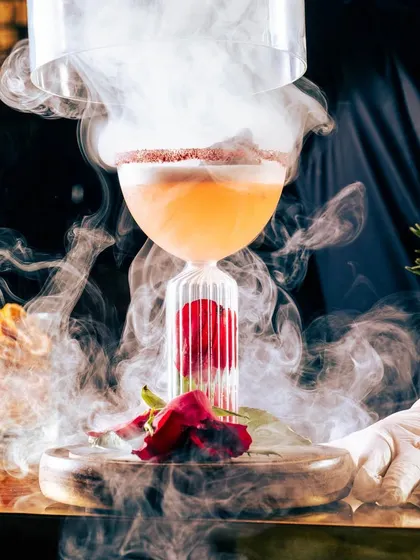 Another view of our dramatic rose cocktail. The smoke-filled cloche is lifted at the table, releasing a fragrant aroma and creating an unforgettable presentation.