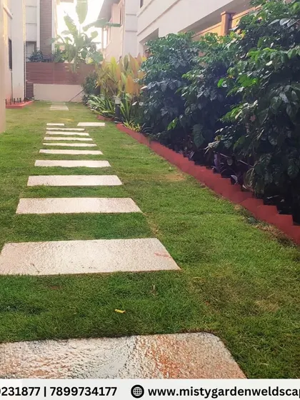 The clean lines of the stepping stone pathway cut through the vibrant green lawn, leading the eye through the newly transformed garden space.
