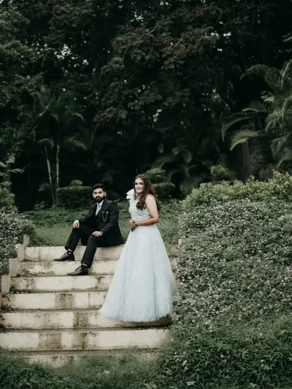 A fairytale moment from an engagement shoot. Her beautiful gown and his sharp suit look perfect against the lush green garden backdrop.