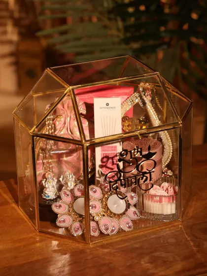 This is one of my favorite Diwali hampers, designed to feel both luxurious and festive. It’s housed in a stunning gold-trimmed glass terrarium and filled with handpicked items like decorative diyas, gourmet treats, and personalized elements.