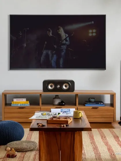 A living room setup featuring the Polk Signature Elite ES55 tower speakers and matching center channel. This system is engineered to deliver dynamic, room filling sound for an authentic American hi-fi experience, backed by 50 years of audio mastery.