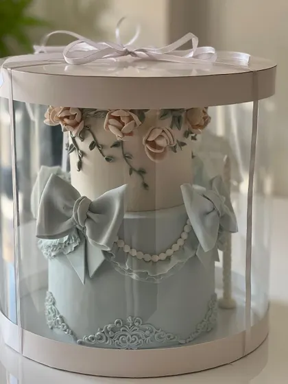 This beautifully packaged two-tiered cake shows the final presentation. Our business courses cover professional packaging solutions to ensure your creations are delivered safely and impressively.