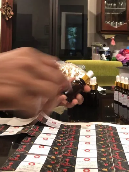 The final step before my products are ready for you: labeling. Here I am, carefully labeling each bottle of my 'Scars to Your Beautiful' face oil. It's a process I do myself to ensure everything is perfect.