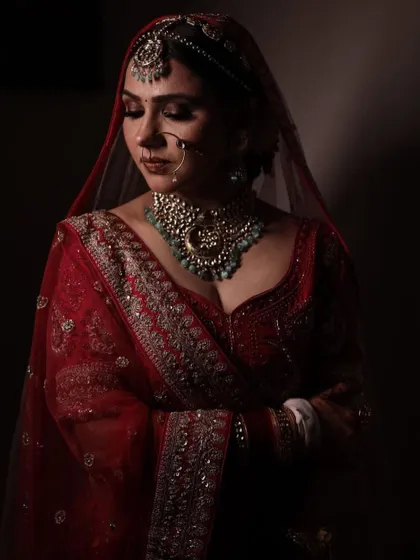 A quiet, reflective moment. The dramatic lighting highlights her beautiful features and the intricate jewellery.