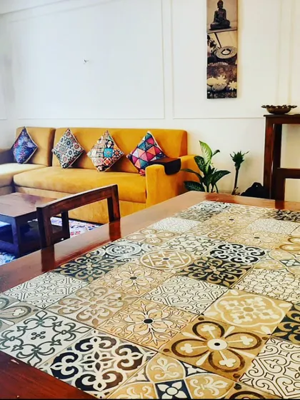We love adding unique, personal touches. For this living room, we refurbished the client's existing dining table by adding a custom top with a mosaic of Moroccan-style tiles, turning it into a statement piece that anchors the room.
