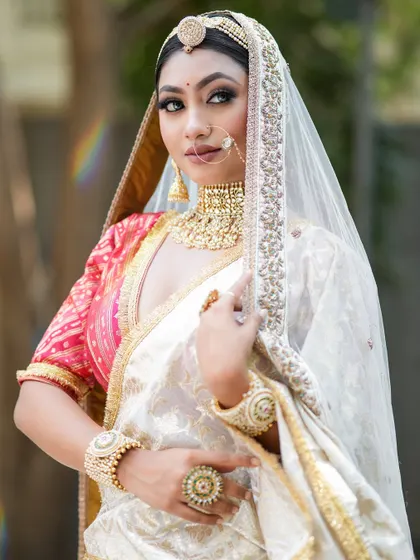 A minimal and subtle makeup look on a beautiful model. The white and red saree is paired with clean, defined makeup and traditional jewelry for a regal appearance.