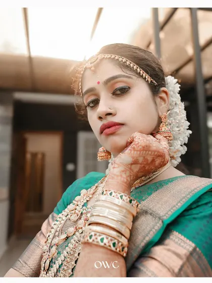 A stunning portrait of a Kerala bride, her gaze intense and captivating, highlighting her beautiful makeup and jewellery.
