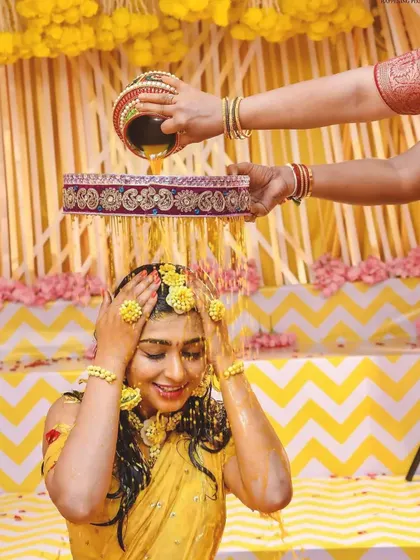 Capturing the pure joy of the Haldi ceremony. The bride is showered with flowers and turmeric, and my decor with its bright yellow drapes and floral accents creates a perfectly festive atmosphere.