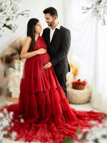 A classic couple's portrait, with the partner in a sharp suit complementing the elegance of the red gown.