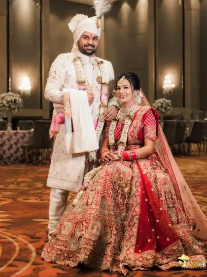 A formal portrait of the couple in their reception hall, showing the grand decor.