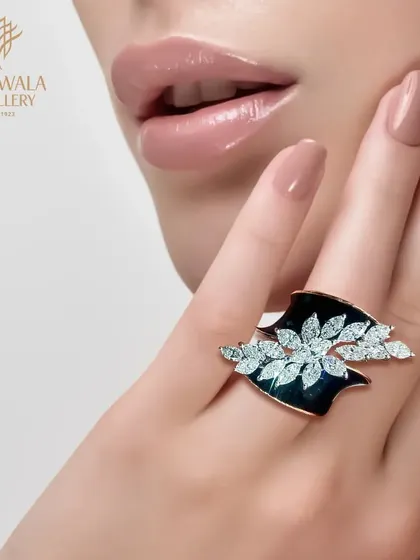 A statement of artistry, this ring features a wing-like design in black enamel and sparkling diamonds. It is a piece for a woman who is not afraid to express her unique style.