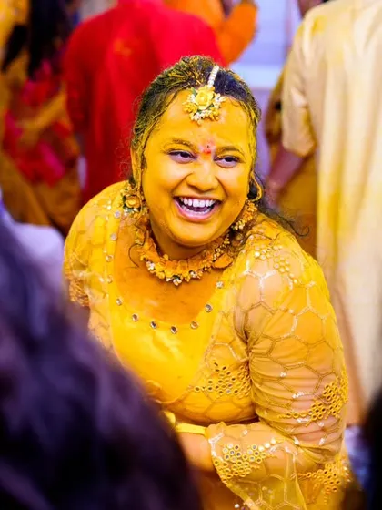The bride, Neha, laughing in the middle of all the haldi madness. Her joyful expression is priceless.