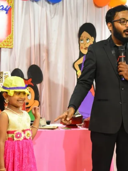 Putting the birthday girl in the spotlight. A little bit of magic and a silly hat with cards on it always gets a great reaction from her and the audience.