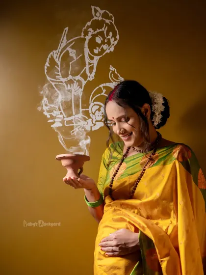 A sacred moment of prayer and blessing for the little one on the way. The artwork of baby Krishna on the wall adds a beautiful, spiritual element to this traditional maternity photo.