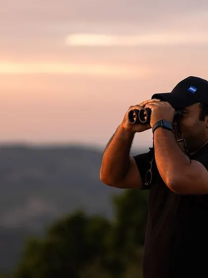 Scanning the horizon at sunset. A huge part of my job is not just photography, but patiently watching and waiting, understanding the environment to predict where the animals will be.