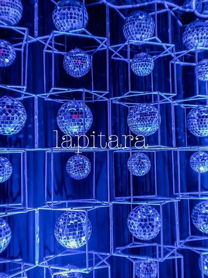 A modern art installation of disco balls arranged in a grid, creating a stunning visual effect with blue lighting.