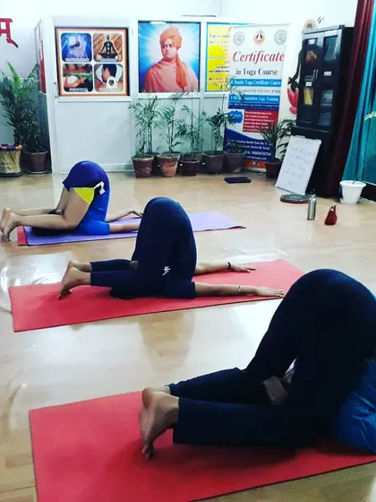 Students in Karnapidasana (Ear Pressure Pose), an advanced inversion that calms the nervous system. We guide students safely into deeper aspects of their practice.