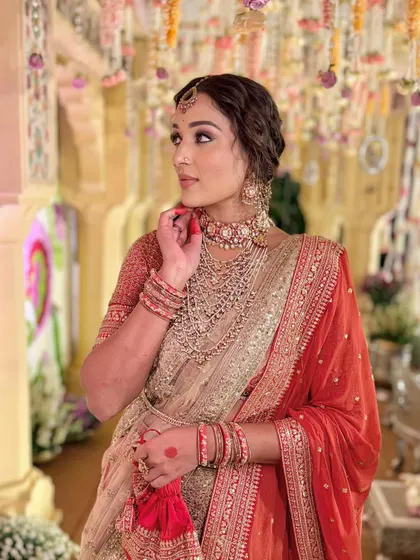 A dramatic pose highlighting the intricate jewellery and the rich colours of the outfit.