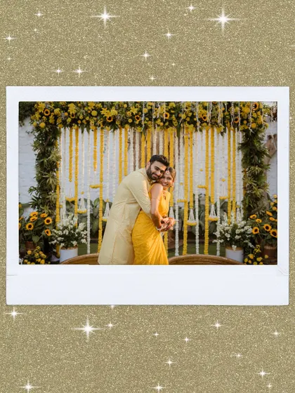 A polaroid-style portrait of the couple at their Haldi ceremony. They are framed by the beautiful yellow floral decor, creating a perfect, happy memory.