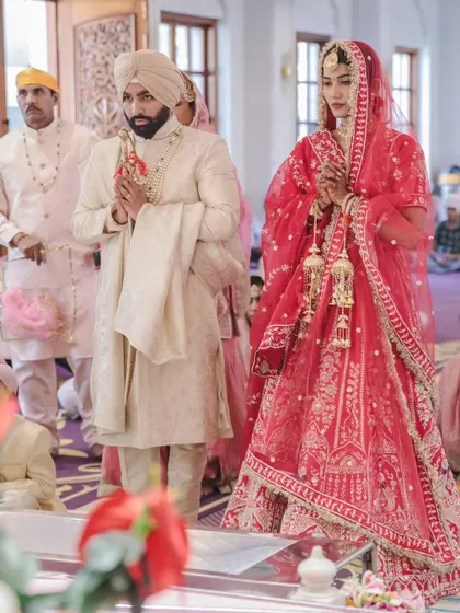 The bride and groom stand with hands joined in prayer during their Anand Karaj ceremony. This is a moment of deep reverence and spiritual connection that I am honored to document.