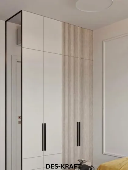 The wardrobe combines clean white doors with a textured wood-like panel, offering a modern storage solution that is both spacious and stylish.