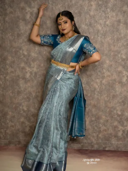 Another dynamic pose showing off the full saree and blouse ensemble. The gold jewelry and waist belt complete this traditional yet stylish look.