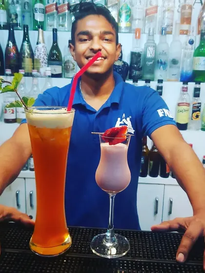A student showcasing two different mocktails, one tall and refreshing, the other creamy and smooth.