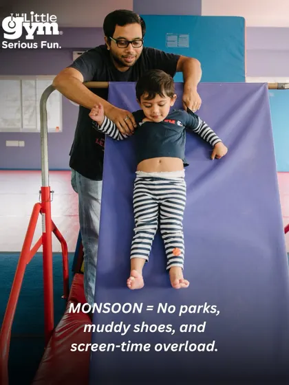 A father carefully guides his toddler down a soft incline mat. This activity helps develop spatial awareness and body control in a safe and supportive way.