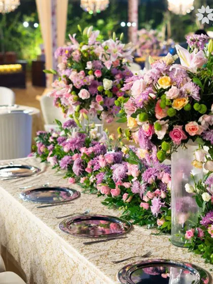A close-up of a lush floral runner, combining various flowers in pastel shades. This style of centerpiece creates a feeling of abundance and natural beauty, making the dining table feel like a garden.