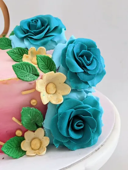 A close-up of the handcrafted teal sugar roses on a pink ombre cake. I love creating detailed floral work that adds a touch of elegance to any design.