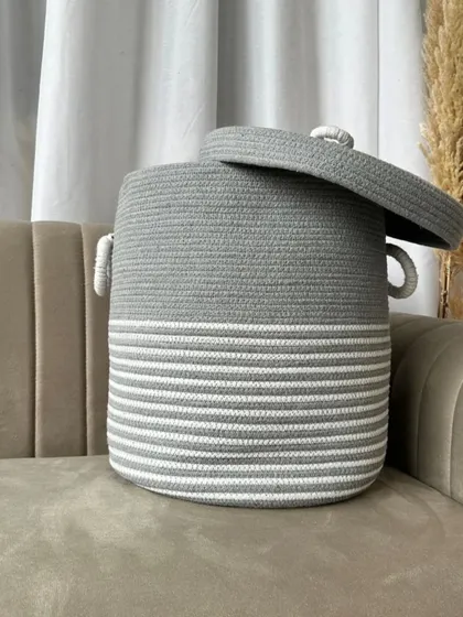 A large, minimalist rope laundry basket in grey and white stripes. Its generous size and sturdy handles make laundry day a little more stylish.