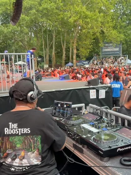 DJing at SummerStage in Central Park. You can see the massive crowd and the beautiful park setting. These free shows for the city are some of my favorite gigs to play.