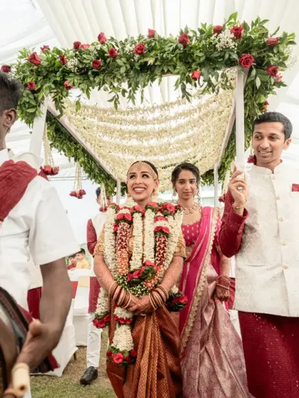 The bride's grand procession, accompanied by traditional musicians and her family. Her happy expression shows her excitement as she makes her way to the mandap.