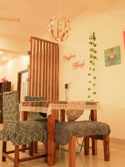 A view of the dining area looking towards the living room, showing how partitions and furniture arrangement can create distinct yet connected spaces in an open-plan layout.