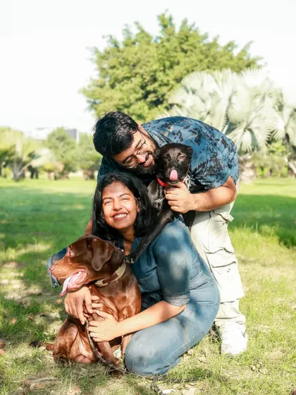 Summers and smiles with the whole furry family. This happy outdoor portrait captures the joy of a couple with their two wonderful dogs.