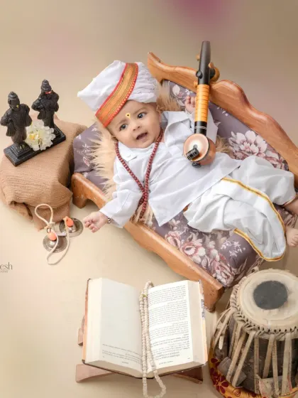 A playful shot of a baby Varkari lying down with his veena. This unique pose adds a fun element to the traditional photoshoot.