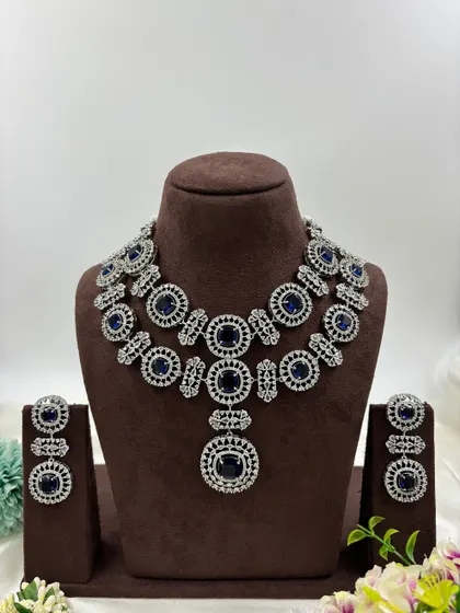 This bold, silver-plated AD set features large circular motifs. It's a statement piece available in sapphire blue, emerald green, ruby red, and all-white, perfect for customers who want to stand out.