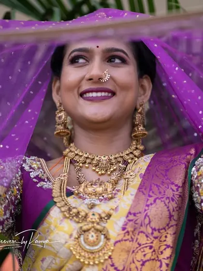 A creative shot using the veil, capturing the bride's happy expression.