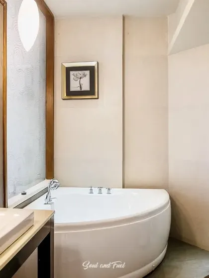 A modern hotel bathroom featuring a clean white bathtub and sink. The neutral tones and simple design create a relaxing and spa-like environment for guests.