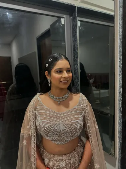 A full view of the bride's contemporary lehenga and hairstyle. The simple, clean lines of the look are effortlessly elegant.