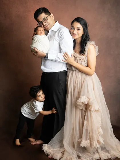 A candid moment where the older brother peeks out from behind his dad. Family shoots with toddlers are always full of fun and surprises.