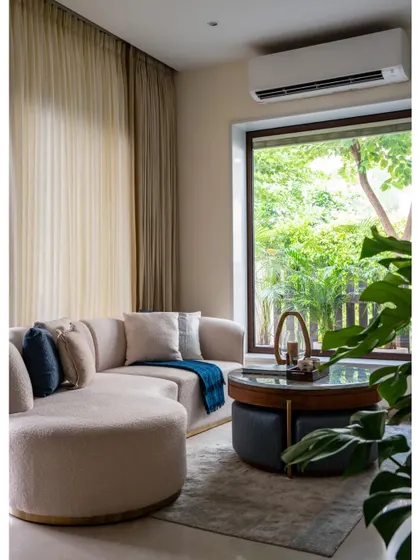 This image from our Villa Tranquility feature highlights the contemporary TV lounge. The curved sofa and large window create a perfect spot for relaxation, demonstrating our skill in creating organic modern spaces.