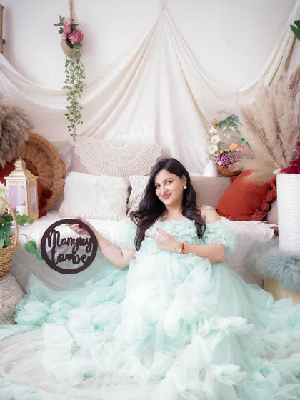 "Mommy to be." This sweet announcement photo features the mom-to-be in a lovely mint green gown, surrounded by a beautiful floral setup.
