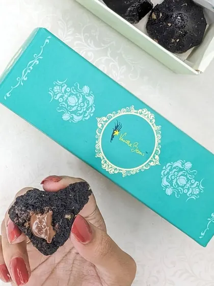 A peek inside our Cake Modak box, showing a Chocolate Modak broken open to reveal its rich, gooey center.
