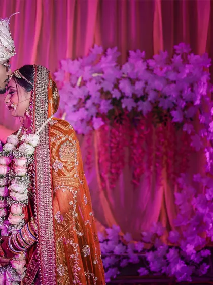 A classic wedding portrait of a groom kissing his bride's forehead, a timeless symbol of love and protection.