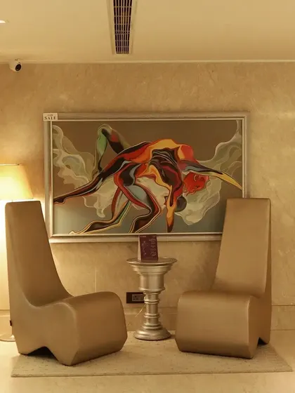 Our salon is a sanctuary of sophistication and luxury. Every corner, like this seating area with modern art, is designed to make your self-care moments feel special.