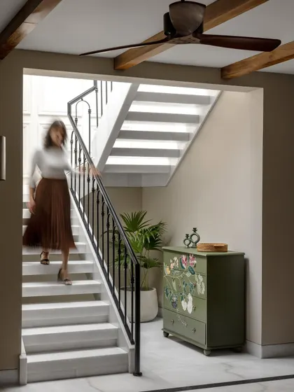 A hand-painted chest of drawers adds a unique, artistic touch to this staircase landing. We believe in incorporating pieces that tell a story and add personality to a home.