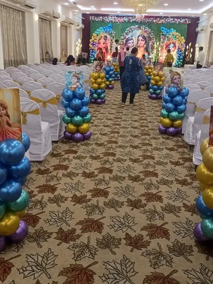 To continue the theme throughout the venue, I created these balloon pillars with illustrations of Radha and Krishna to line the aisle, making the entire hall feel festive.