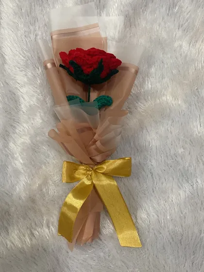 Another angle of the single red rose, showing the layers of wrapping paper and the elegant gold bow.